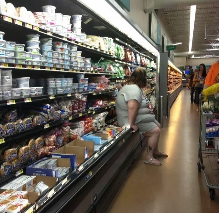 Shoppers inside a Walmart store aisle with various dairy and bakery products on the shelves, highlighting unusual store moments.