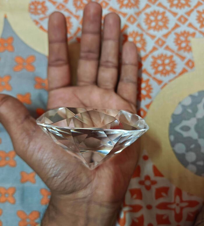 Hand holding a large faceted crystal diamond, illustrating one of the weirdest math problems solved by people.