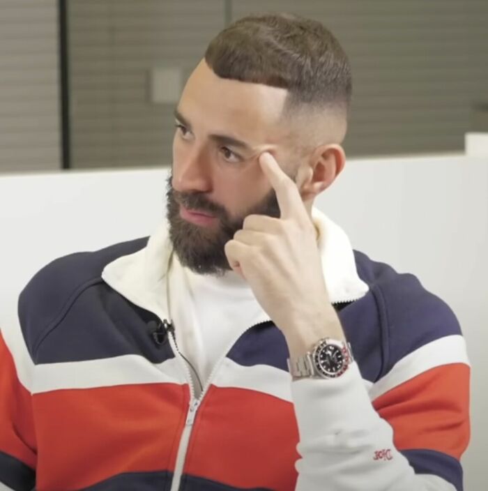Karim Benzema in a casual jacket, sitting thoughtfully and highlighting key moments of his football career.