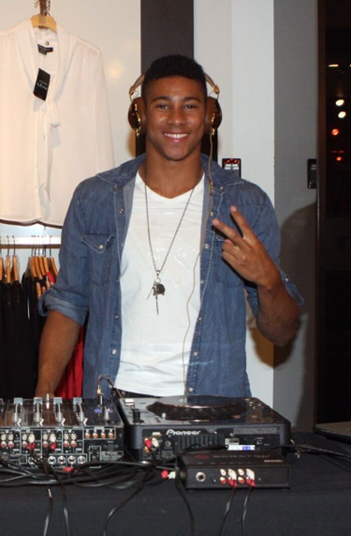 Keiynan Lonsdale DJing with headphones and a smile, showcasing career highlights and bio in a casual setting