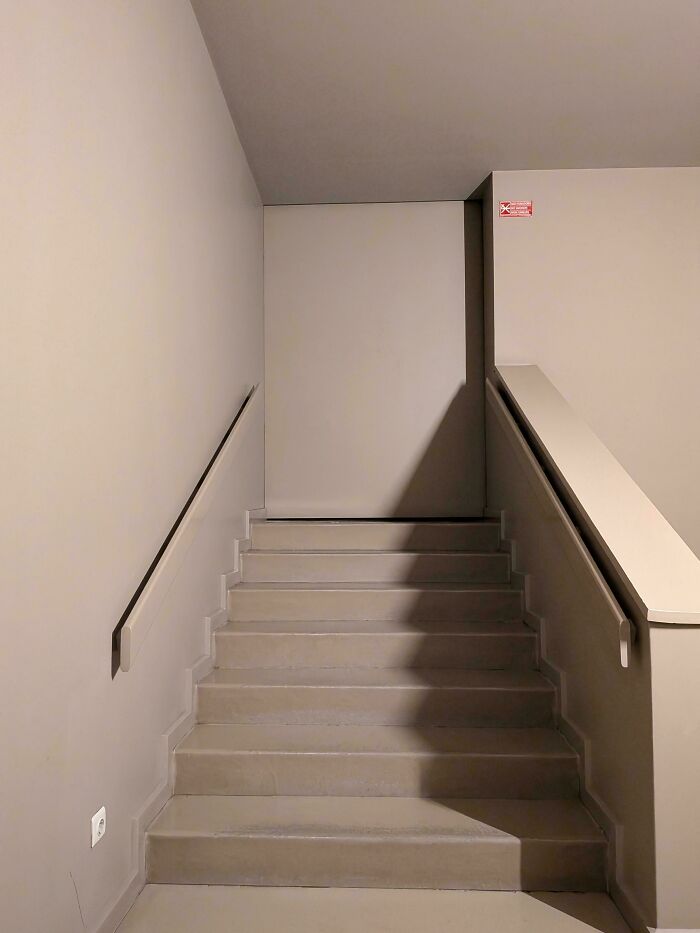Empty stairway leading to a blank wall, creating a creepy liminal space that resembles the backrooms atmosphere.