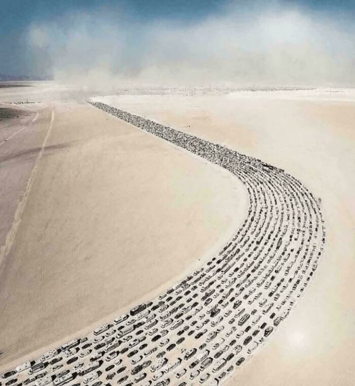 A long line of cars in a desert landscape creating a surreal liminal space resembling the backrooms atmosphere.