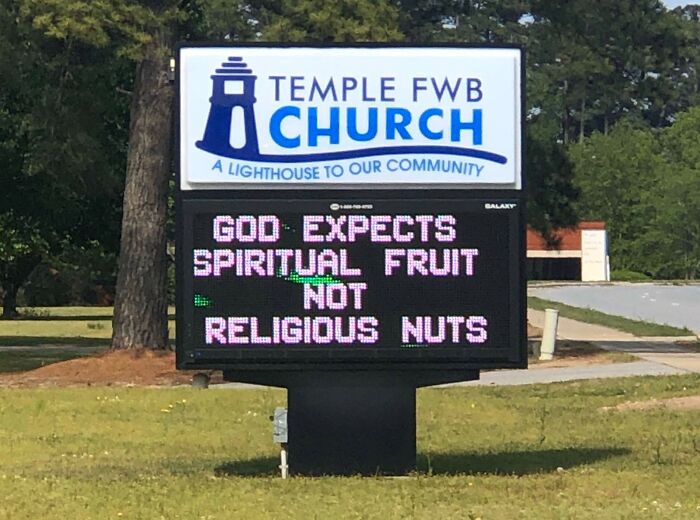 Church sign at Temple FWB with a joke about God expecting spiritual fruit, not religious nuts, outdoors on a sunny day.