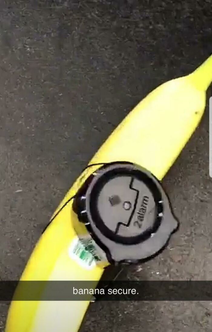 Banana with Walmart security tag attached on black surface in a funny and confusing Walmart people moment.