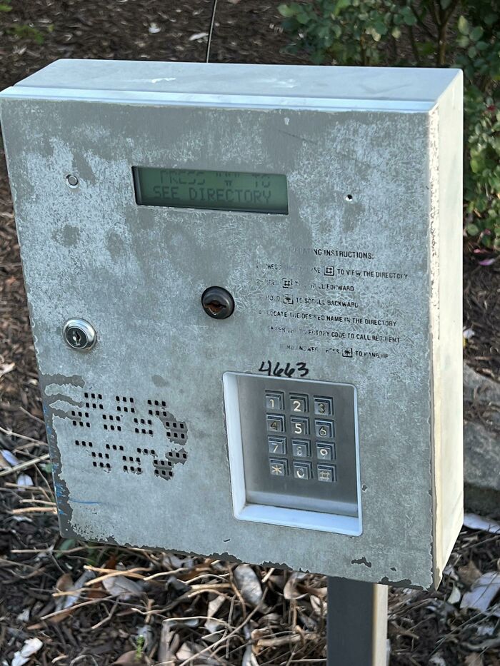 Worn metal gate intercom with keypad and scribbled graffiti, illustrating next-level jerks.
