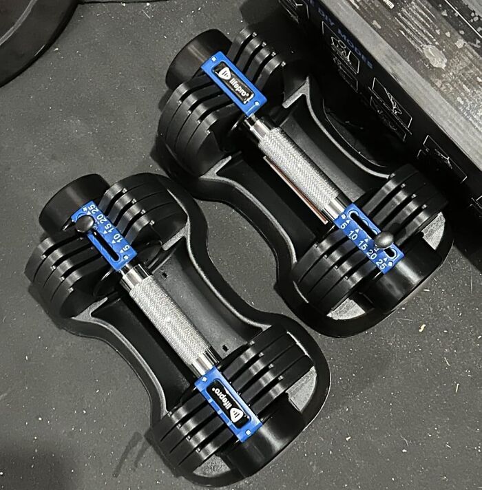 Adjustable dumbbells on a gym floor, perfect for apartment friendly fitness routines to help smash your fitness goals.