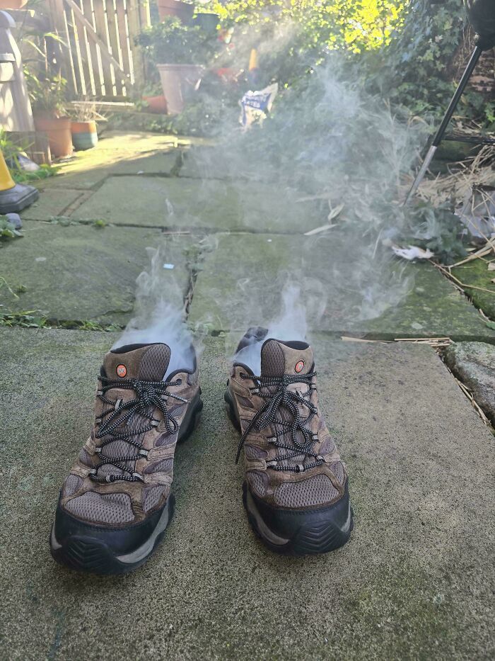 Funny Pictures steaming hiking shoes on a backyard patio with smoke rising and sunlight on paving stones