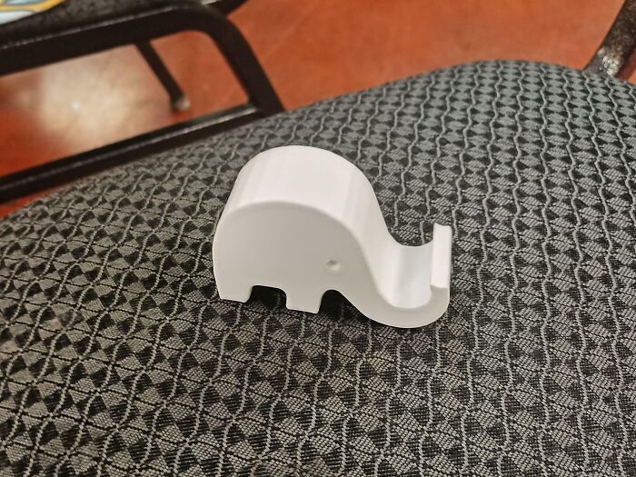 Small white elephant-shaped object placed on a patterned chair, one of the most bizarre things people received as Christmas gifts.