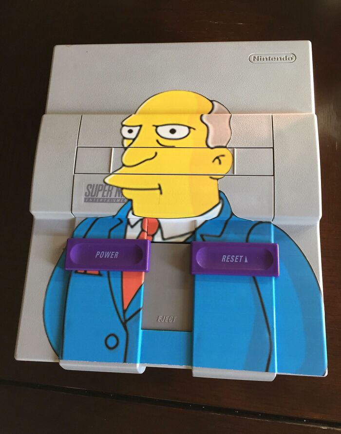 Vintage Super Nintendo console with a bizarre cartoon character decal, an unusual Christmas gift idea.