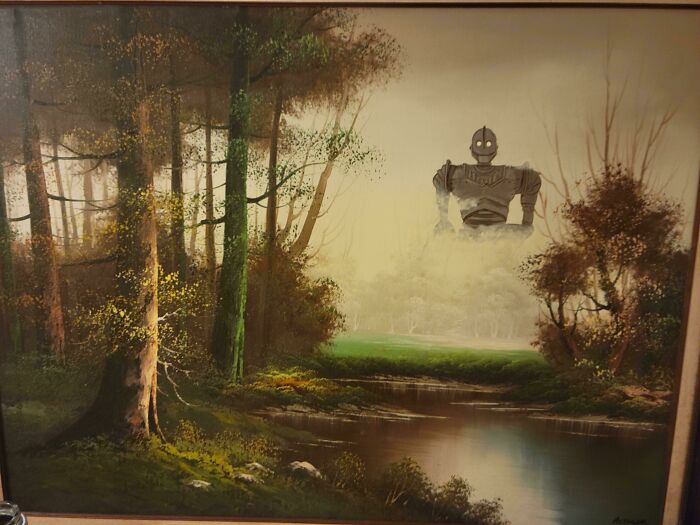 Thrifted painting of a forest and river personalized with a humorous unexpected large robot figure in the background.