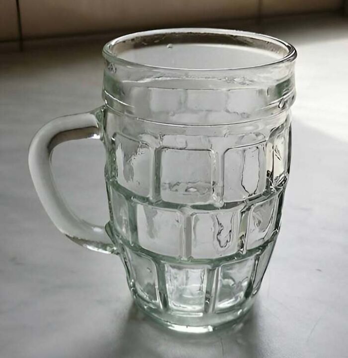 Clear glass mug with textured square patterns on a kitchen counter, relatable to Eastern Europe humor and memes.