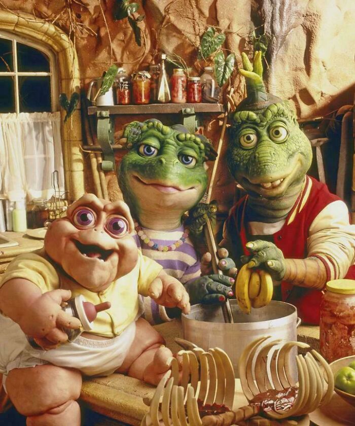 Animated dinosaur family cooking in a cozy kitchen, evoking 90s and 2000s nostalgia from childhood TV shows.