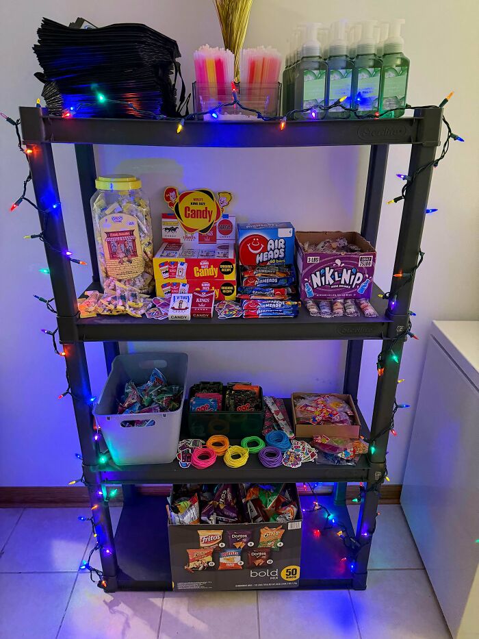Shelf decorated with colorful lights holding nostalgic 90s and 2000s candy, snacks, and childhood treats.