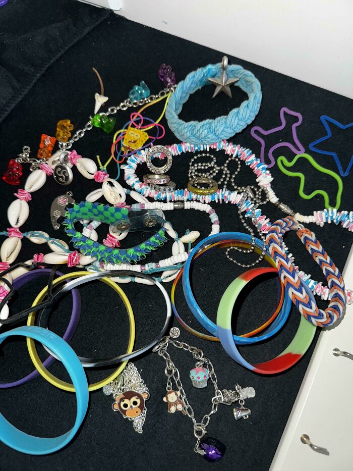 Collection of 90s and 2000s nostalgia bracelets, rings, and colorful accessories evoking childhood memories and retro fashion trends.