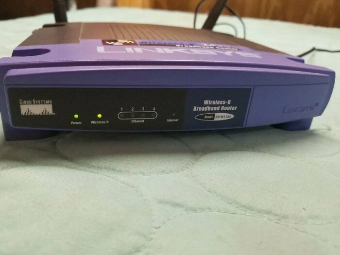 Vintage purple Linksys Wireless-B broadband router from the 90s and 2000s nostalgia era, capturing childhood tech memories.