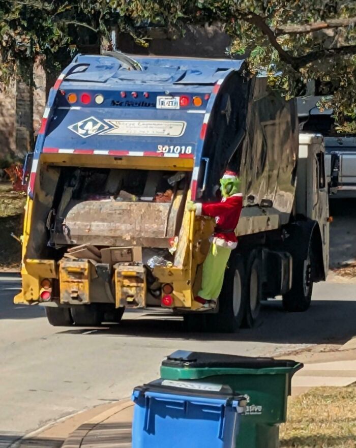 Person dressed as the Grinch riding a garbage truck during holiday moments capturing festive and sweet holiday spirit scenes.