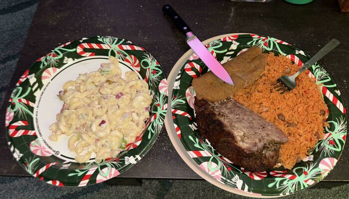 Holiday meal with macaroni salad, meatloaf, and rice served on festive plates with candy cane and holly design.