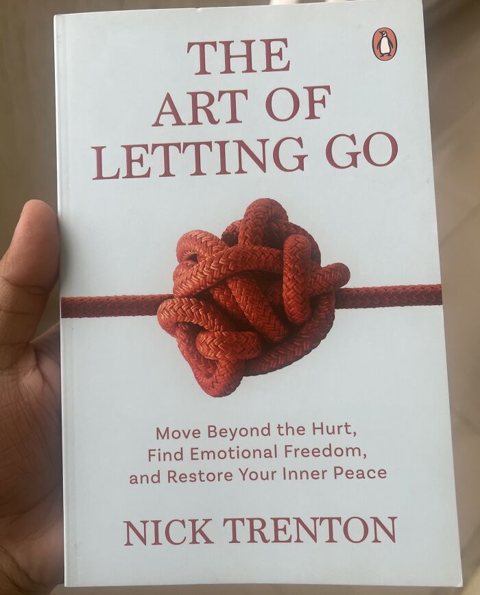 Hand holding the book The Art of Letting Go, an example of hilariously bad Secret Santa gifts people have actually received.