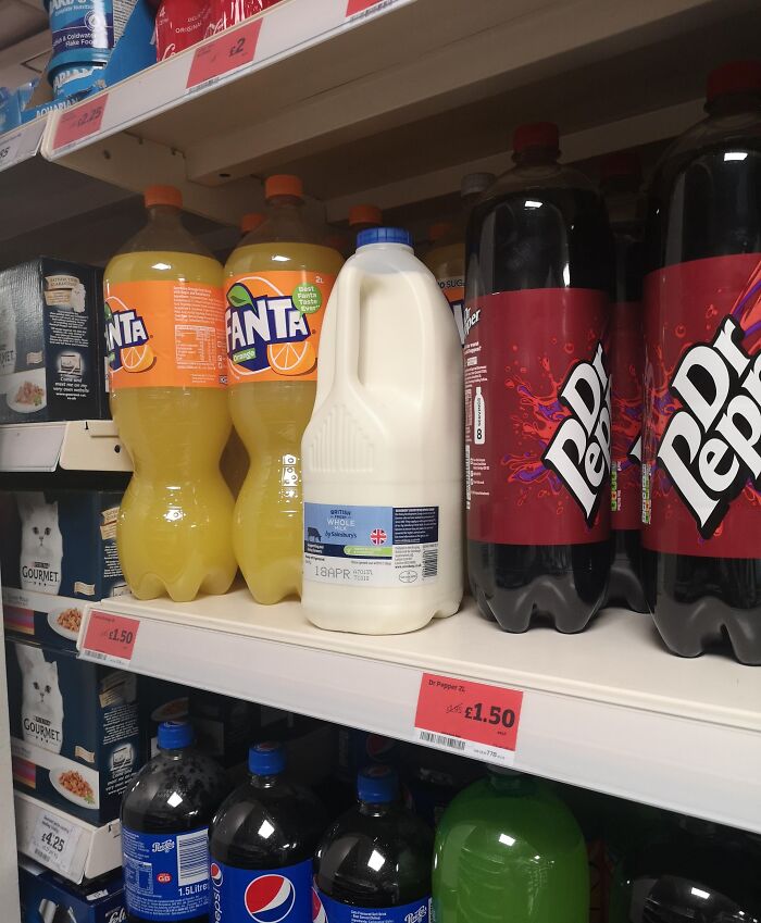 Milk bottle shoved between Fanta and Dr Pepper bottles on supermarket shelf, example of next-level jerks