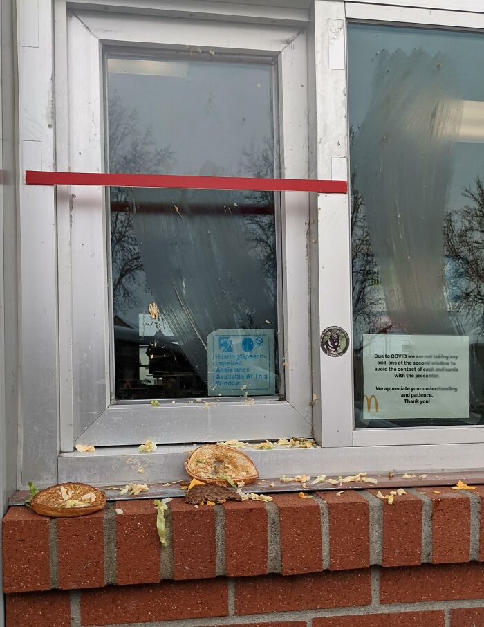 next-level jerks throw smashed burger and lettuce at fast-food drive-thru window, food and smears on ledge and glass