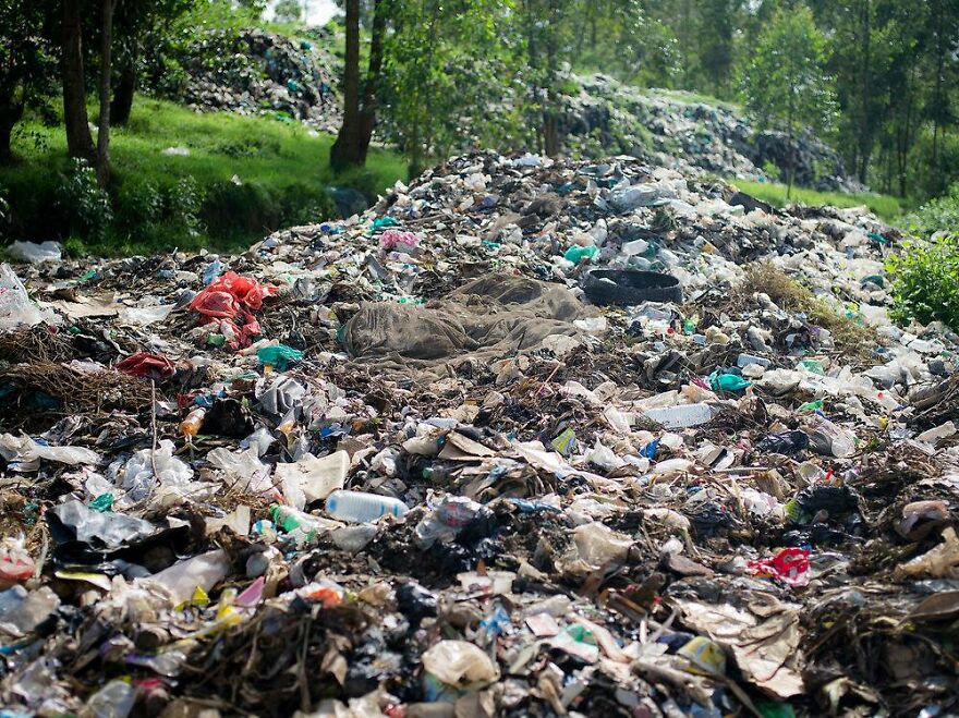 Mountain of garbage waste in an outdoor area surrounded by trees representing pollution in the dirtiest countries in the world.
