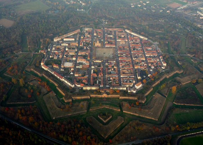 Aerial view of a star-shaped fortress town surrounded by greenery, one of the places that look AI generated but are real.