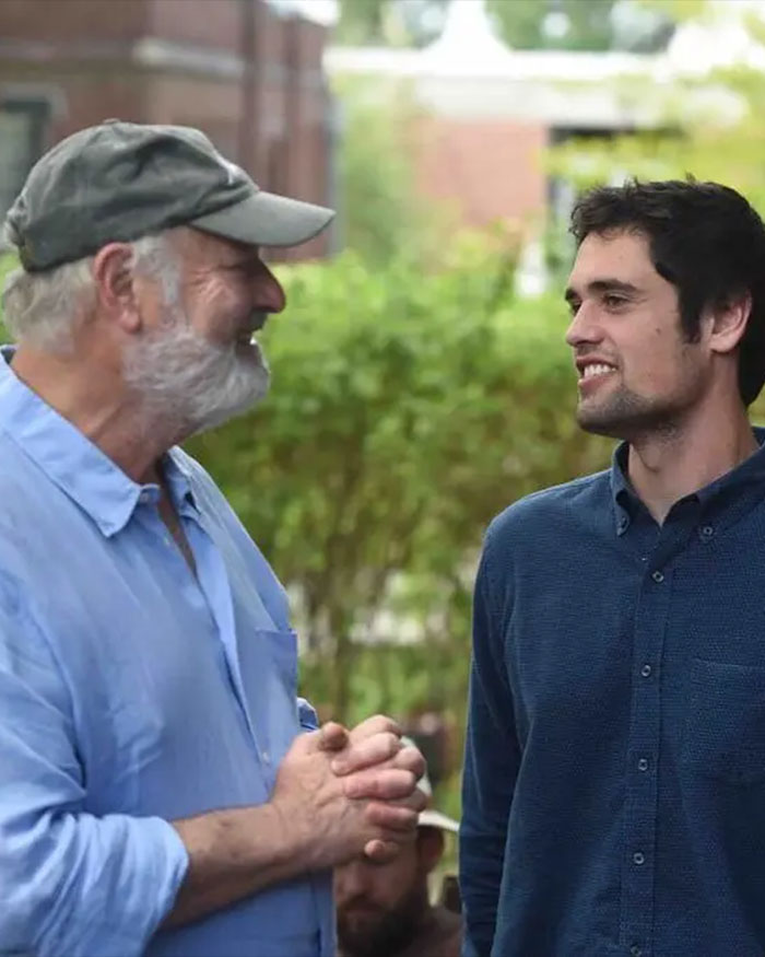 Two men having a conversation outdoors, illustrating Nick Reiner's startling diagnosis and alleged erratic behavior before homicides.
