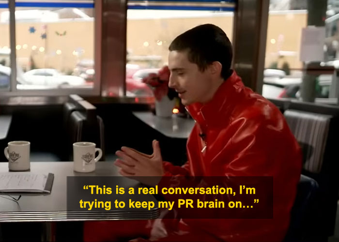 Timothée Chalamet in red jacket during interview, facing criticism for perceived arrogance in public appearance. Timothée Chalamet in red jacket during interview, facing criticism for perceived arrogance in public appearance.