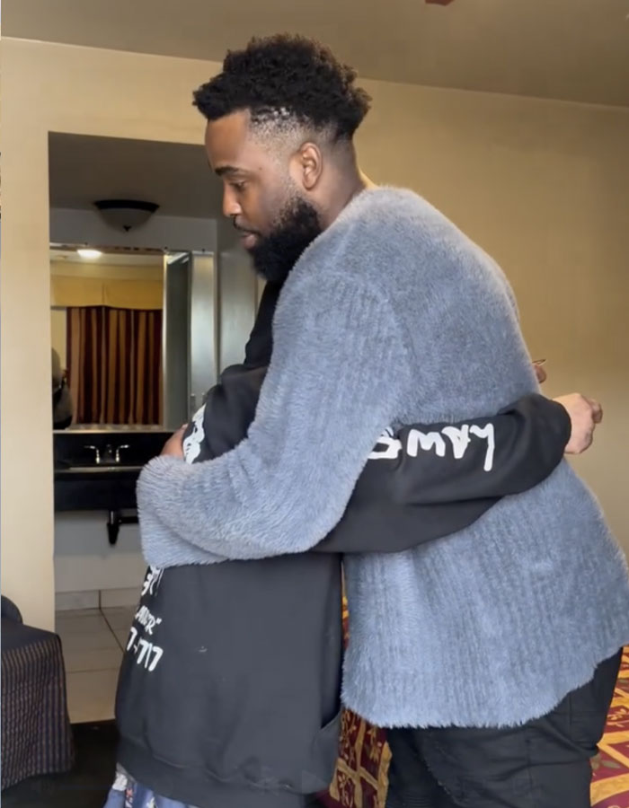 Man hugging another person indoors, illustrating the dad of Nickelodeon star Tylor Chase with a sad health update and life struggles.