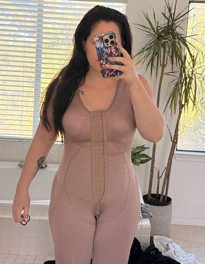 Jenelle Evans taking a mirror selfie wearing a beige compression garment after a drastic mommy makeover procedure. Jenelle Evans taking a mirror selfie wearing a beige compression garment after a drastic mommy makeover procedure.