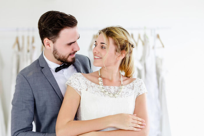 Couple in wedding attire sharing an intimate moment, capturing unexpected family drama in a candid setting.