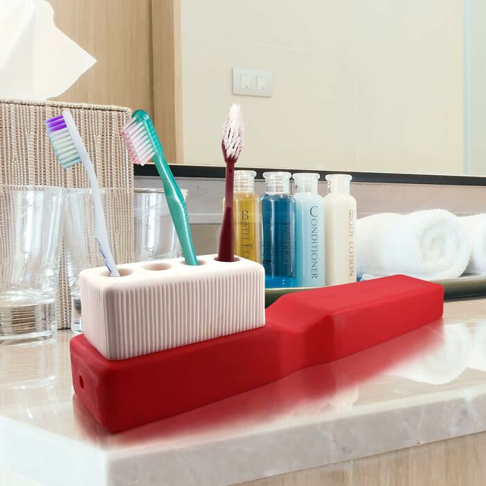 Toothbrush holder gift in quirky design on bathroom counter with toiletries and towels, perfect for gloriously unhinged taste.