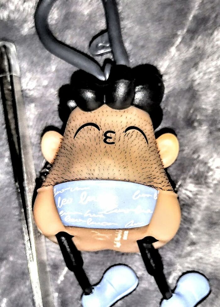 Funny gag gift keychain with cartoon face wearing a mask, perfect for friends who dislike scented candles.