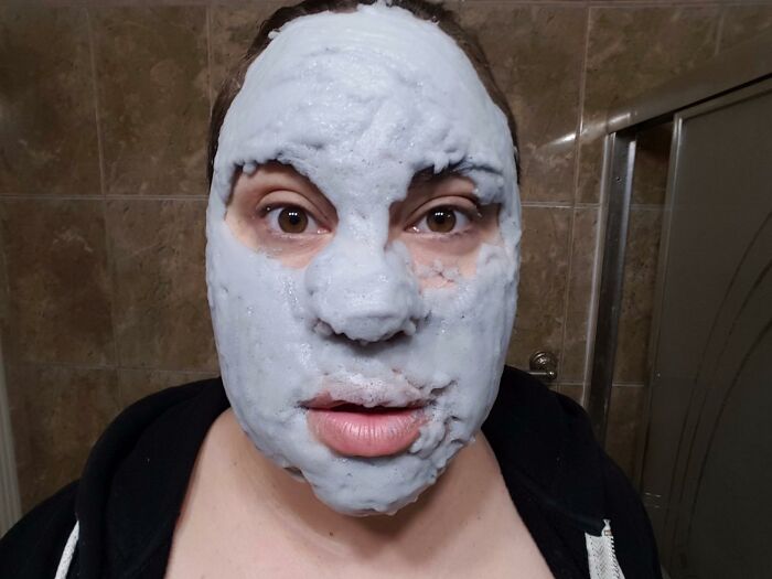 Person with a thick white facial mask in a bathroom, illustrating best sellers that show we were a little delusional in 2025.