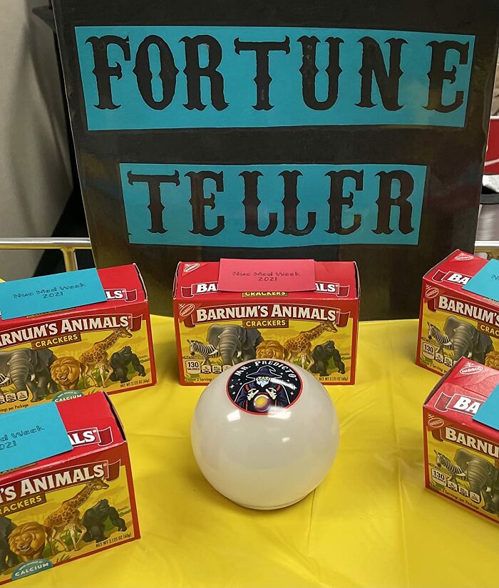Fortune teller display with Barnum’s Animals crackers and a white prediction ball on a yellow tablecloth.