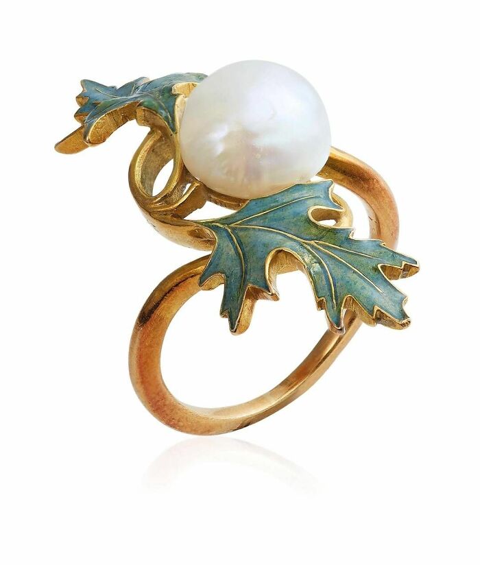 Vintage gold ring with pearl and green leaf design, showcasing culture and everyday life through powerful old photos.