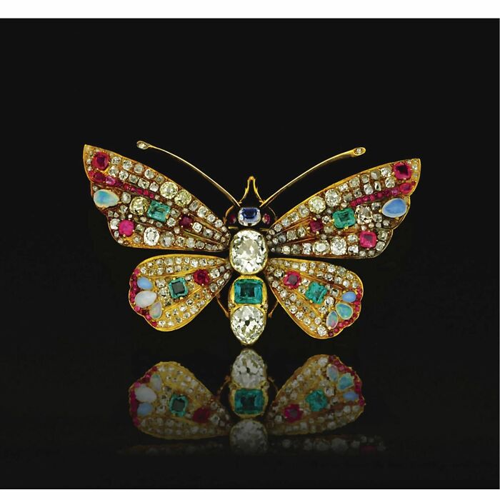 Intricately designed vintage butterfly brooch adorned with colorful gemstones, showcasing culture and emotion from the past.