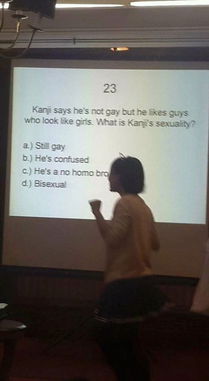 Person standing in front of a projected funny multiple-choice question about Kanji's sexuality in a random pics collection.