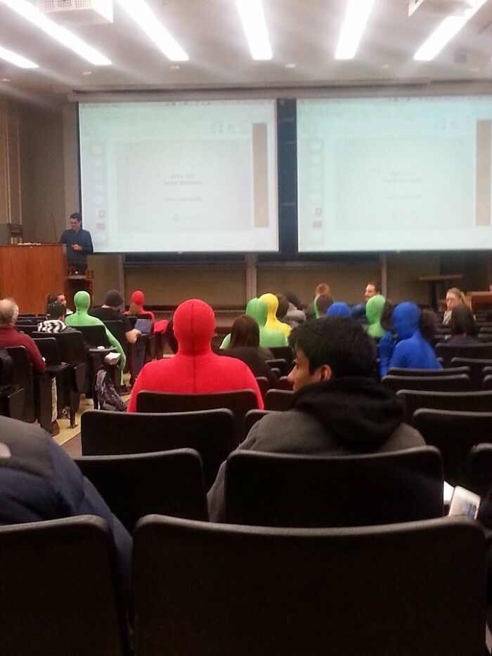 Students in colorful full-body suits sitting in a classroom, creating a random picture that makes you laugh before you know why.
