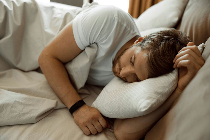 Young man sleeping peacefully on a bed, representing couples revealing the toughest things they chose to forgive.