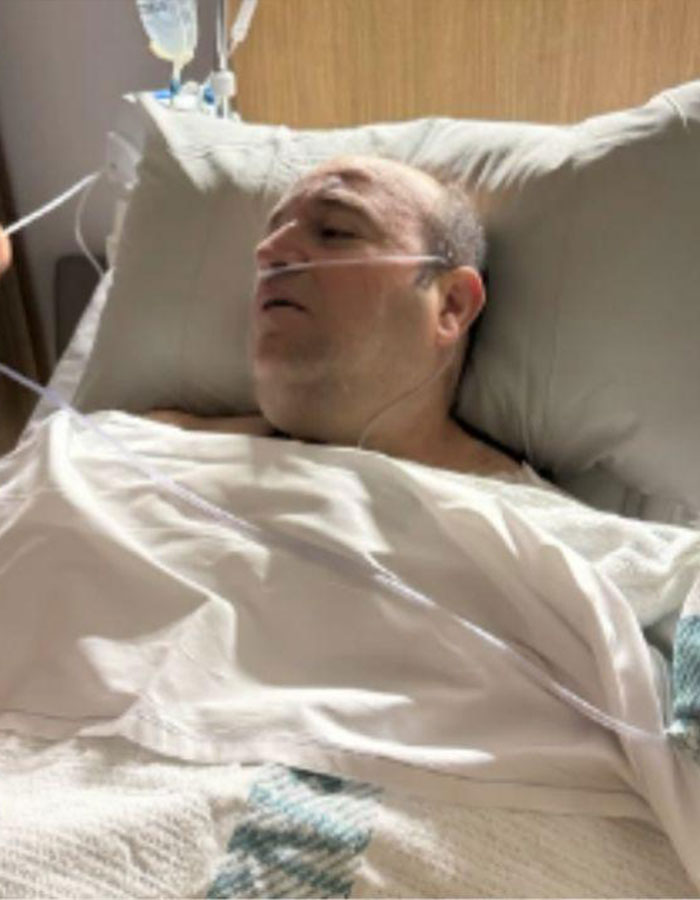 Man resting in hospital bed with oxygen tube, recovering after Bondi Beach hero disarms attacker during Hanukkah event. Man resting in hospital bed with oxygen tube, recovering after Bondi Beach hero disarms attacker during Hanukkah event.
