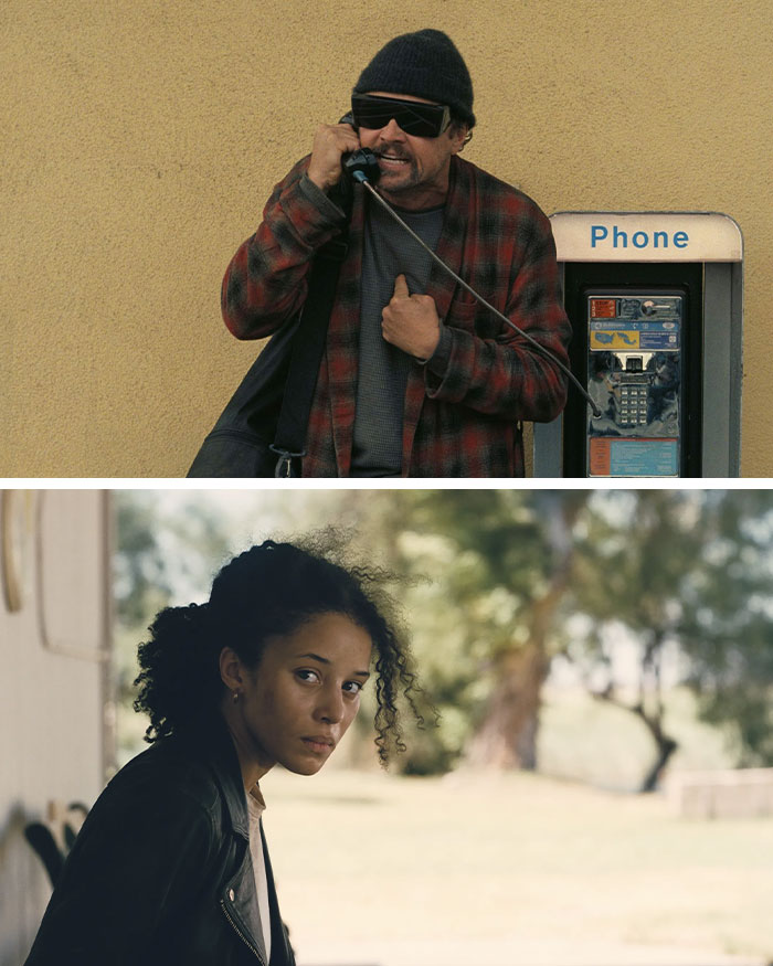 Man wearing sunglasses and beanie using a payphone and woman in leather jacket outdoors in natural light.