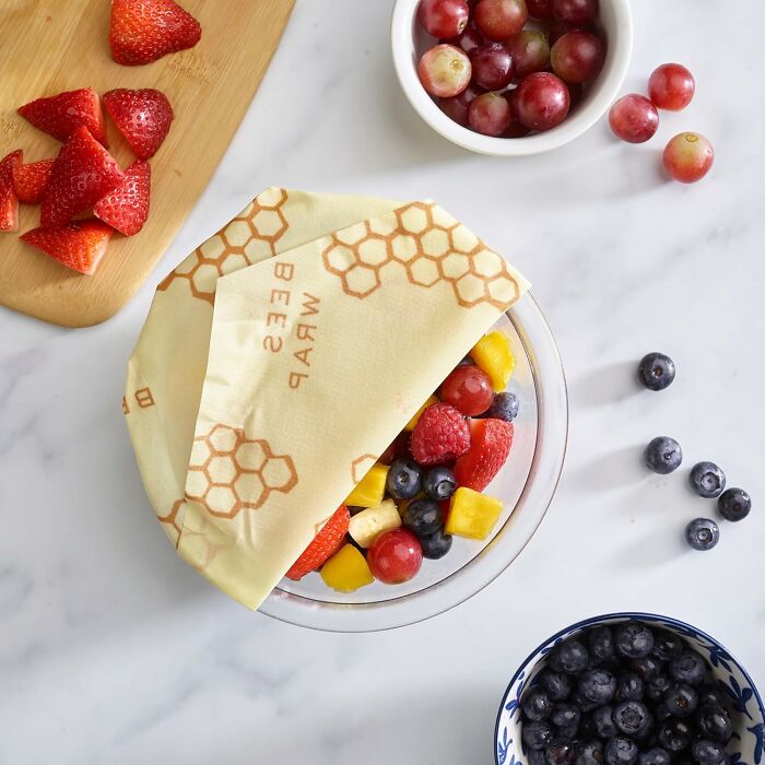 Reusable beeswax wrap covering a bowl of mixed fruit, a unique gift for the person who has everything.