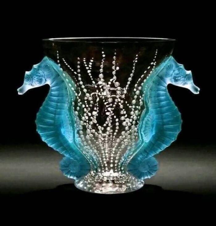 Decorative vintage glass vase with seahorse handles showcasing culture and artistry from the past.