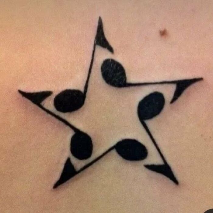 Black tattoo of a star formed by connected musical notes on skin, showcasing trippy pictures style and abstract design.
