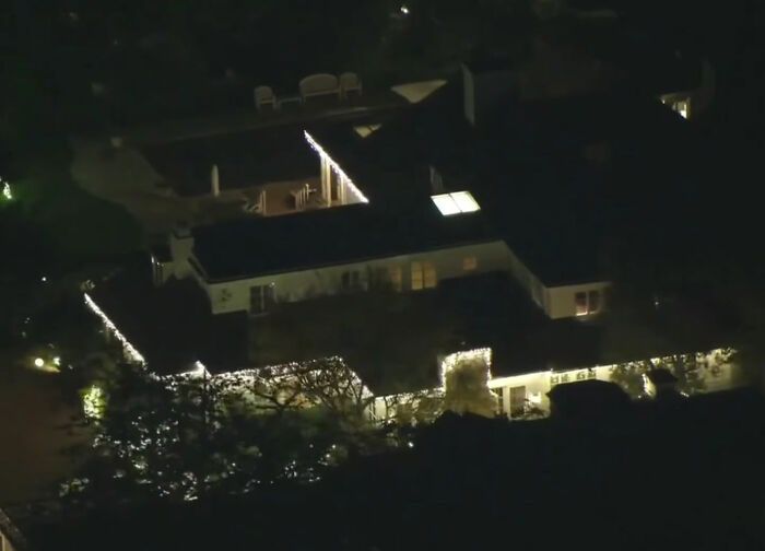 Aerial nighttime view of a house with holiday lights, illustrating MAGA hypocrisy discussions related to Rob Reiner and Charlie Kirk.