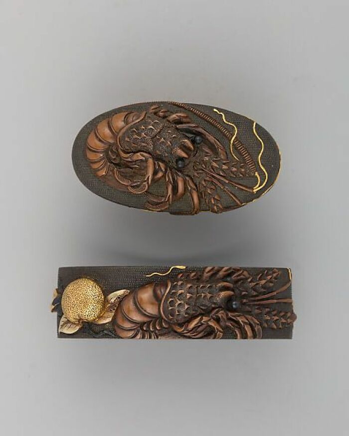 Intricately carved old samurai sword fittings featuring a lobster design, capturing culture and craftsmanship of the past.