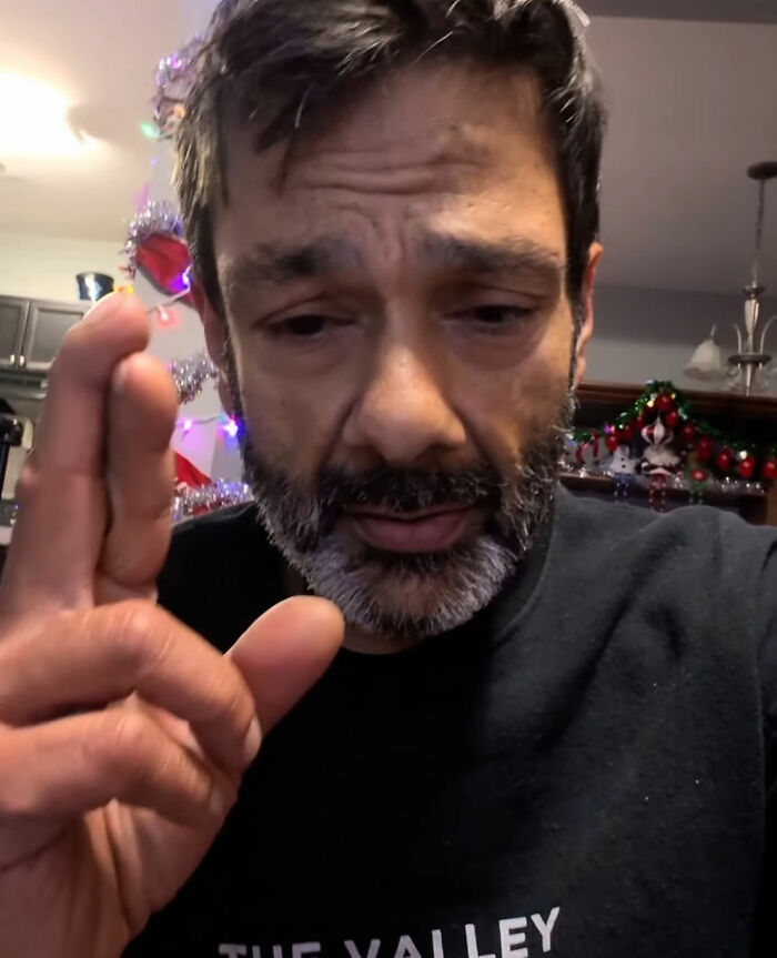 Man with a beard and serious expression raising hand, relating to Tylor Chase&rsquo;s hospitalization and friend&rsquo;s revelation.