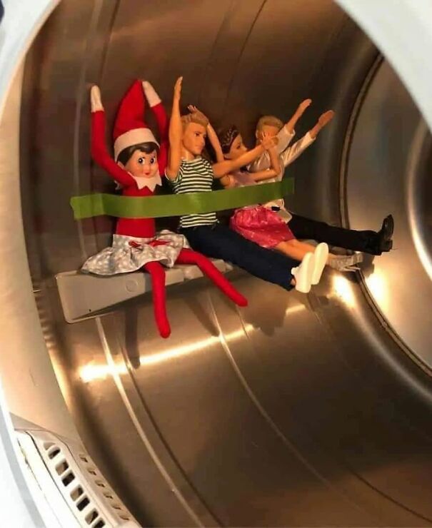 Elf on the Shelf and dolls tied with tape inside a washing machine, creating a playful and mischievous scene.