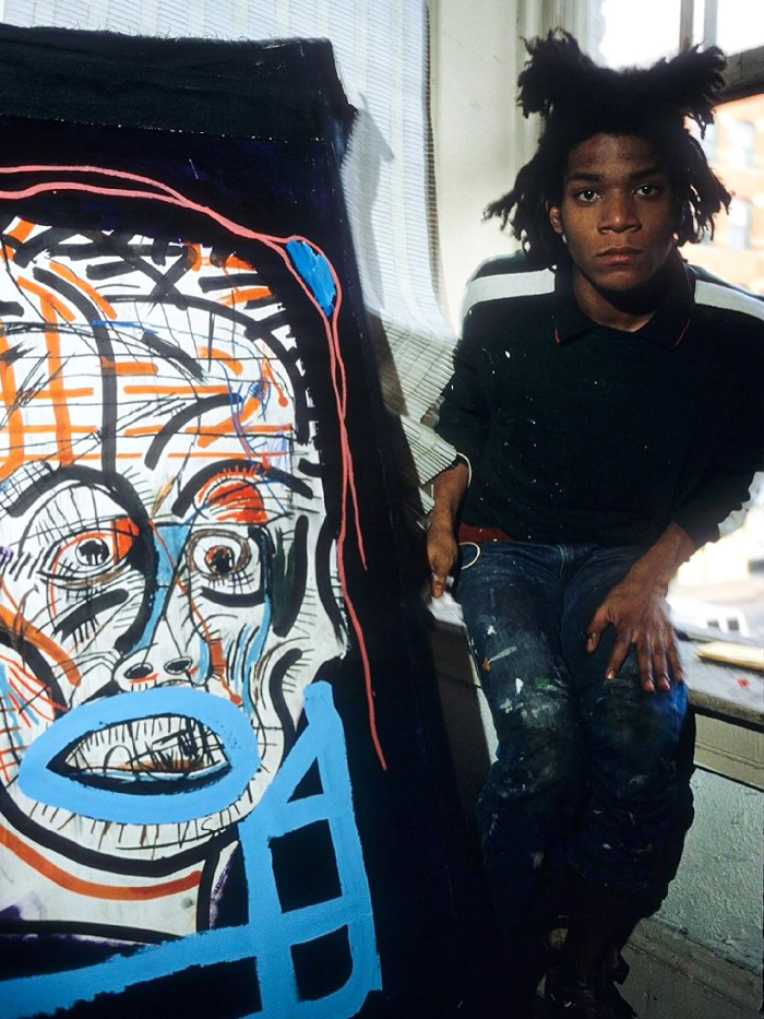 Artist Jean-Michel Basquiat in NYC studio with colorful abstract painting, showcasing unique creative expression in the city.